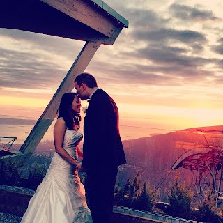 two people getting married on a mountaintop at sunset